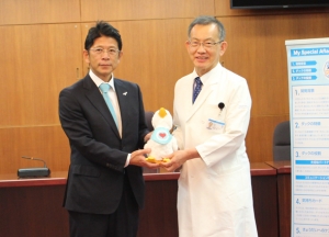 東内支社長（左）から「My Special Aflac Duck」を受け取る塚原教授