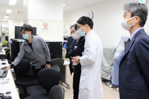 IVRセンターで凍結療法の説明を受ける松尾氏（左から2人目）